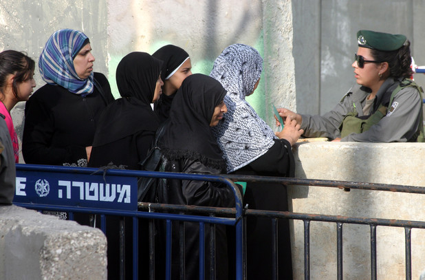 Israeli border policemen check the IDs of the Palestinian female worshippers